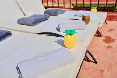 a row of tables with towels and a pineapple on them at full home pool terrasse résidence alqaria assiyahiya in Marrakech