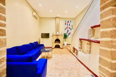 a living room with a blue couch and a tv at full home pool terrasse résidence alqaria assiyahiya in Marrakech