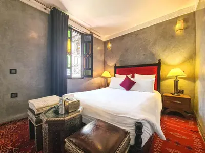 a bedroom with a large bed and a window at Riad Jaime in Marrakech
