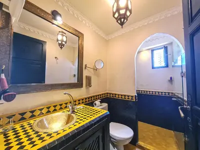 a bathroom with a sink and a toilet and a mirror at Riad Jaime in Marrakech