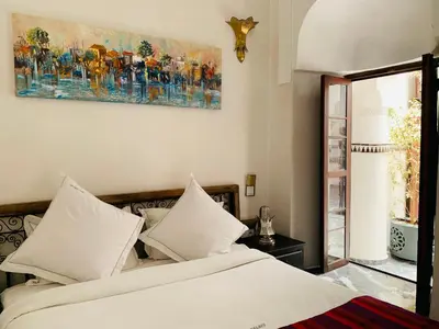 a bedroom with a bed and a painting on the wall at Palais Aix Kabaj &Spa in Marrakech