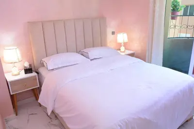 a bedroom with a large white bed with two lamps at apartment Marrakech, gueliz in Marrakech