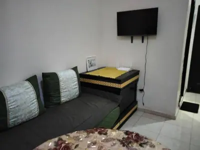 a living room with a couch and a flat screen tv at les porte de guiliz appartement in Marrakech