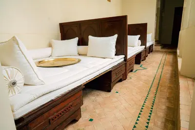 a row of wooden beds with white pillows on them at Riad Dar Zaouia in Marrakech