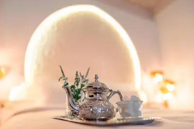a tea kettle and a cup on a table at Riad L'ECOLE in Marrakech