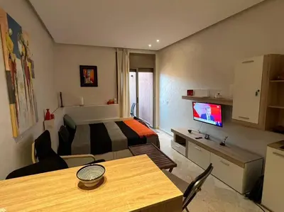 a hotel room with a bed and a table with a television at Nid douillet à Gueliz in Marrakech
