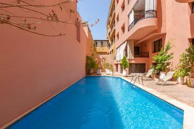 a swimming pool in the courtyard of a building at Le Palmier - Appartement Authentique à Gueliz in Marrakech