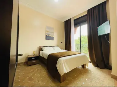 a bedroom with a bed and a large window at The Villa avec piscine chauffée 4 chambres in Marrakech