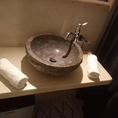 a bathroom sink with a large stone sink at Riad Laila Marrakech in Marrakech