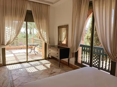 a bedroom with a bed and a balcony at palmeraie village 2 in Marrakech