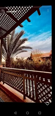 a wooden fence with a palm tree in the background at palmeraie village 2 in Marrakech
