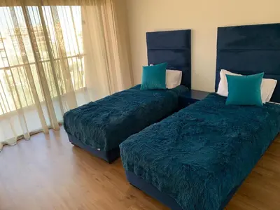 a bedroom with two beds with blue sheets and a window at Appartement deux chambres salon Centre de Gueliz 23 in Marrakech