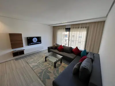 a living room with a couch and a flat screen tv at Appartement deux chambres salon Centre de Gueliz 23 in Marrakech