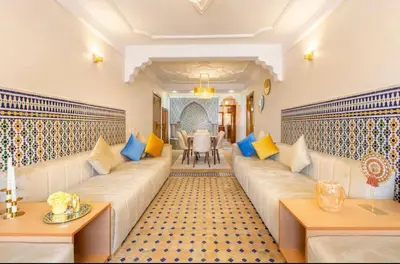 a living room with a long couch with colorful pillows at Luxury Appartement gueliz center in Marrakech