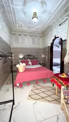 a bedroom with a pink bed in a room at Riad Hayat in Marrakech