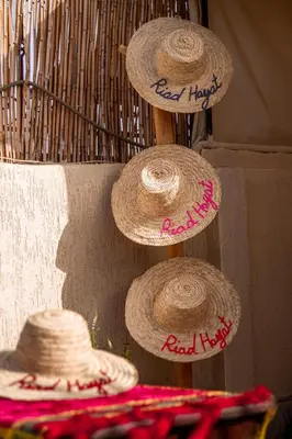 a group of straw hats hanging on a wall at Riad Hayat in Marrakech