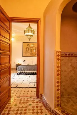 a bedroom with a bed and a chandelier at Riad Thé d'Orient - Piscine Privée - Petit Déjeuner in Marrakech