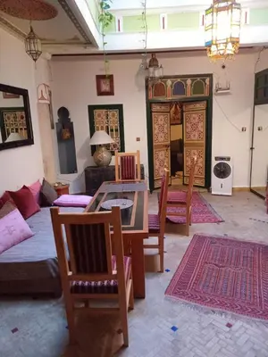 a living room with a table and chairs and a couch at Riad El Badii chambre twin Bahia in Marrakech