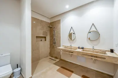 a bathroom with two sinks and a shower at Le Palais de l Atlas luxury villa Marrakech in Douar Ouled Ahmed