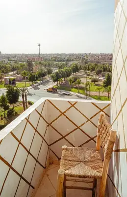 a chair on a balcony with a view of a street at Apartment in Marrakech in Marrakech