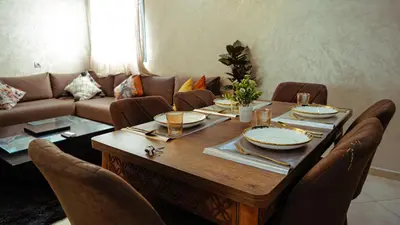 a dining room table with chairs and a couch at Apartment in Marrakech in Marrakech