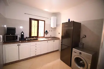a kitchen with a refrigerator and a washer and dryer at KECHDAYS, Lovely apartment near airport in Marrakech