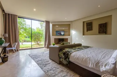 a bedroom with a bed and a large window at Villa Tomazo Marrakech in Marrakech
