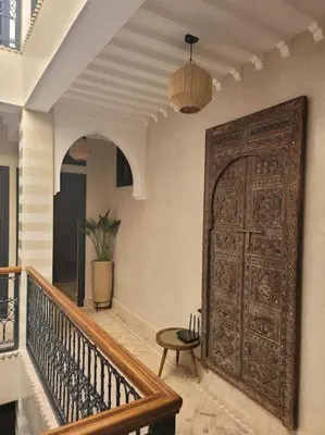 a large wooden door in a room with a staircase at Riad Isahiac avec piscine en exclusivité in Marrakech
