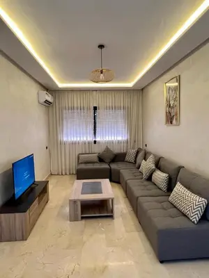 a living room with a couch and a tv at appartement 2chambres salon Nour8 in Marrakech