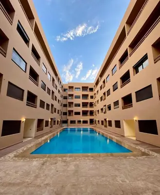 an empty courtyard of a building with a swimming pool at appartement 2chambres salon Nour8 in Marrakech