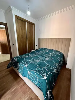 a bedroom with a bed with a blue comforter at appartement 2chambres salon Nour8 in Marrakech