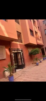 a building with a door and potted plants in front of it at Superbe Appartement proche centre marrakech, neuf tout équipé in Marrakech