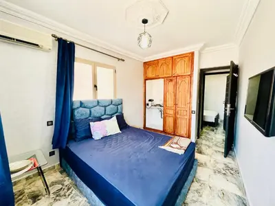 a blue bed in a room with a window at Al Hanae Family Aparts in Marrakech