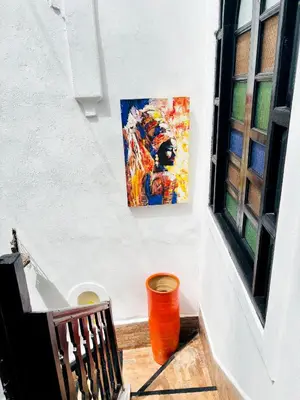 a painting hanging on a wall next to a window at Riad Darna 4 chambres avec piscine et petit déjeuner in Marrakech