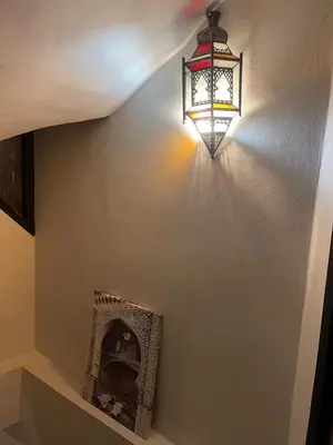 a light hanging on a wall with a fireplace at Riad Baroud in Marrakech