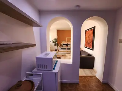 a living room with a microwave sitting on a table at Suite dans la palmeraie refaite à neuf grande Terrasse Dar Dmana in Marrakech