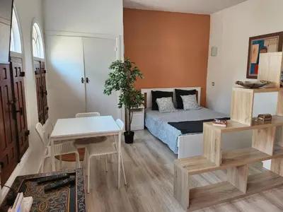 a bedroom with a bed and a table and chairs at Suite dans la palmeraie refaite à neuf grande Terrasse Dar Dmana in Marrakech