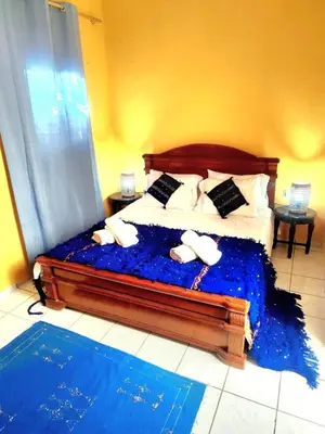 a bedroom with a bed with blue sheets and pillows at Riad Izza in Marrakech