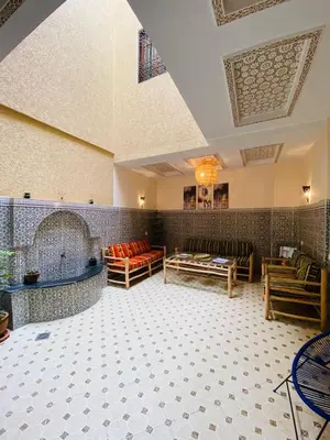 a large room with couches and tables in a building at Private Riad 3ch Salon, Terrasse avec Jacuzzi , à Jemaa El Fna in Marrakech