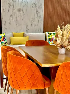 a dining room with a wooden table and orange chairs at Appartement Marrakech avec piscine privée in Marrakech