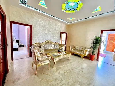 a living room with a couch and a table at Appartement Marrakech avec piscine privée in Marrakech