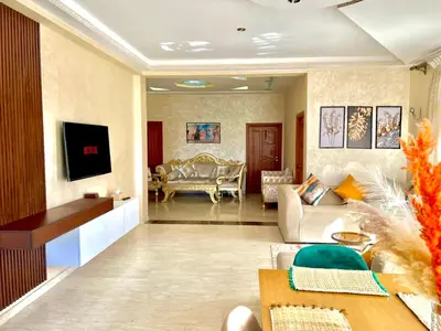 a living room with a couch and a tv at Appartement Marrakech avec piscine privée in Marrakech