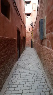 an alley with a stone walkway between two buildings at Riad Dar Lilas in Marrakech