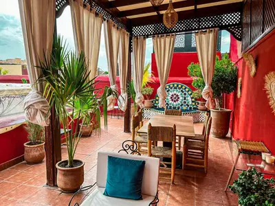 a patio with a table and chairs and plants at Riad La Bigarade in Marrakech