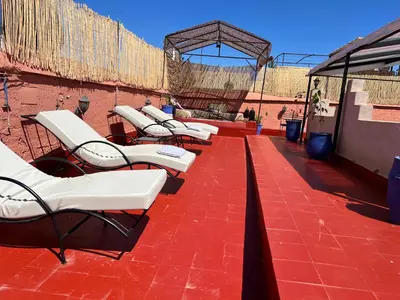 a row of lounge chairs on a red brick patio at Riad el Adraoui in Marrakech