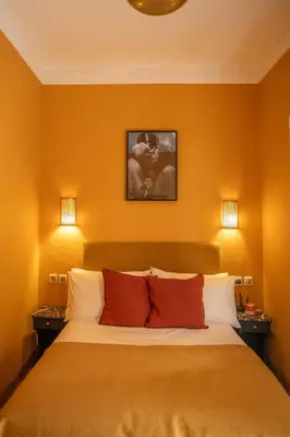 a bedroom with a large bed with orange walls at Riad Le Petit Bacha in Marrakech
