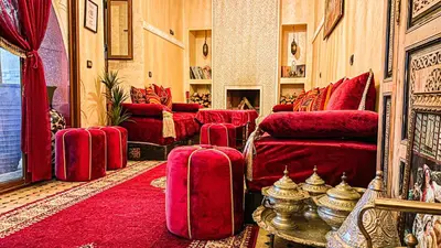 a living room filled with red furniture and red carpet at Riad Safir Marrakech in Marrakech