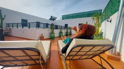 a woman sitting in a chair on a balcony at Riad Safir Marrakech in Marrakech