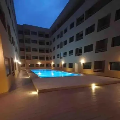 a large building with a swimming pool in front of it at Glamorous Marrakech in Marrakech