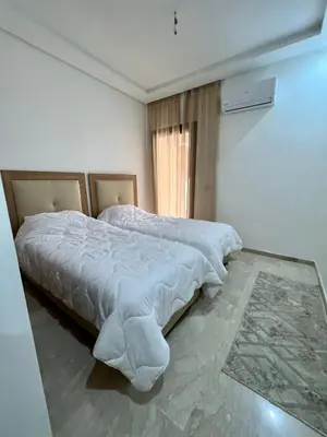 a bedroom with a large bed with white sheets at Apparemment deux chambres salon 16 in Marrakech